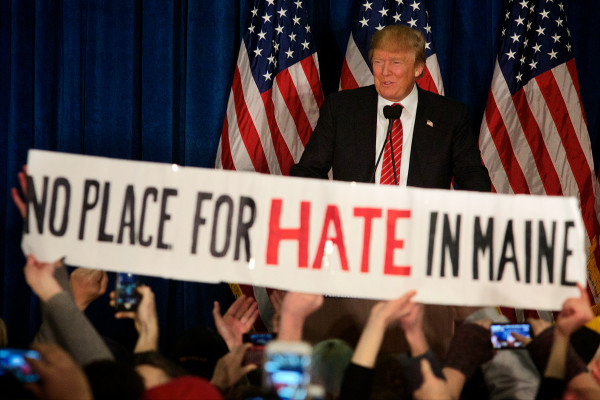 Donald Trump Slammed, PORTLAND, MAINE -- 03/03/16 -- A protestor unfurls a banner at a Donald Trump campaign rally in Portland on Thursday. The proceedings were interrupted four times by similar protests. Troy R. Bennett | BDN