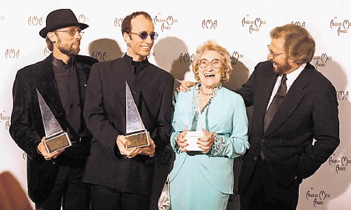 Barbara Gibb, The Bee Gees, winners of the International Award at the American Music Awards, pose with their mom, Barbara Gibb backstage at the American Music Awards at the Shrine Auditorium in Los Angeles, Monday, Jan. 27, 1997. The brothers Gibb are, left to right, Barry, Robin and Maurice. (AP Photo/Michael Caulfield)