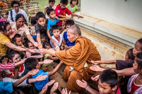 monk surrounded by children 933624